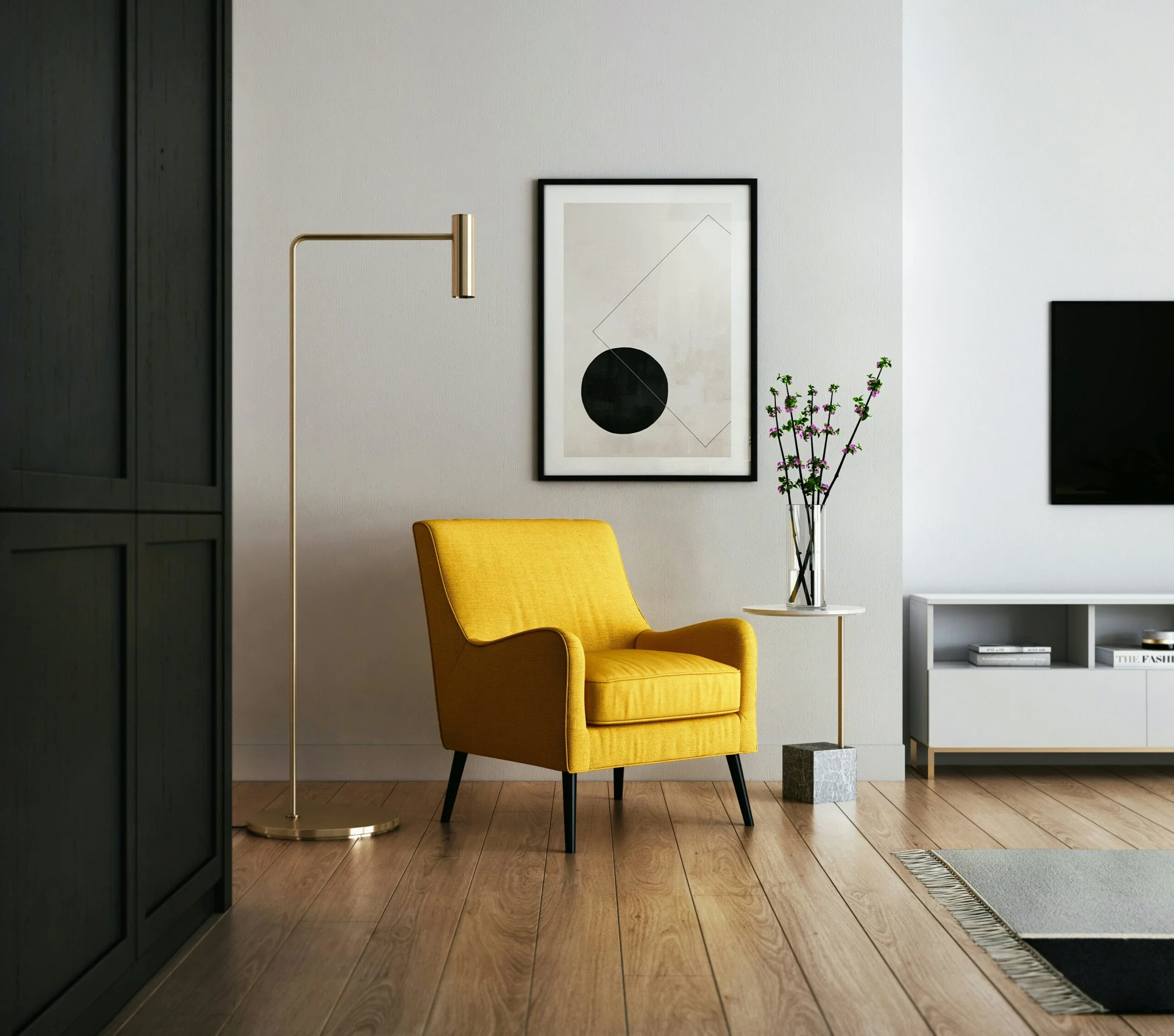 Bright yellow armchair beside a gold floor lamp and framed geometric art in a modern living room corner.